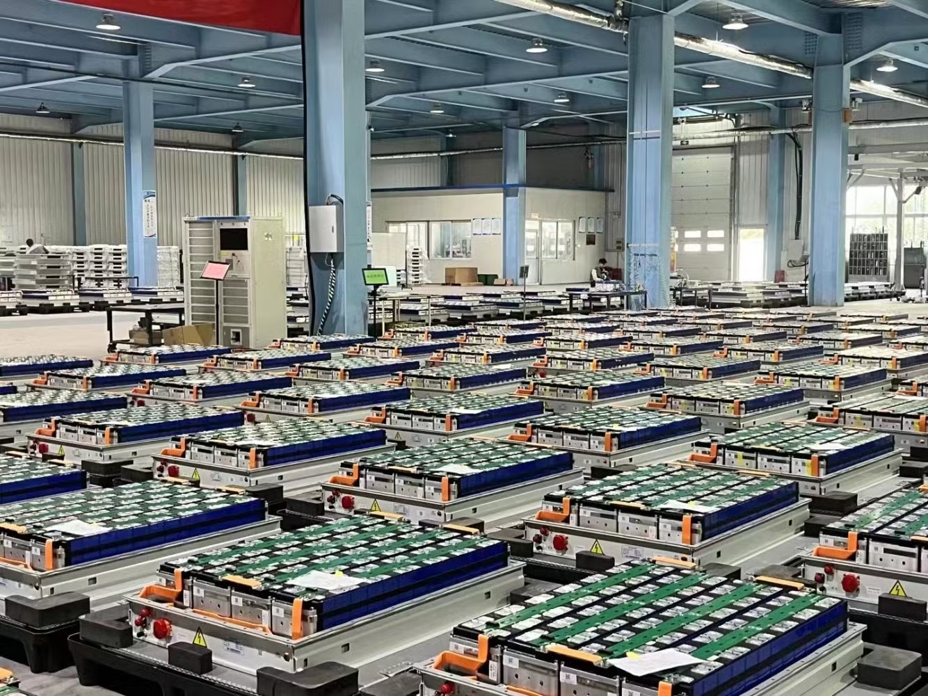 Battery packs staged in a warehouse facility for assessment, grading, and routing to second-life or recycling